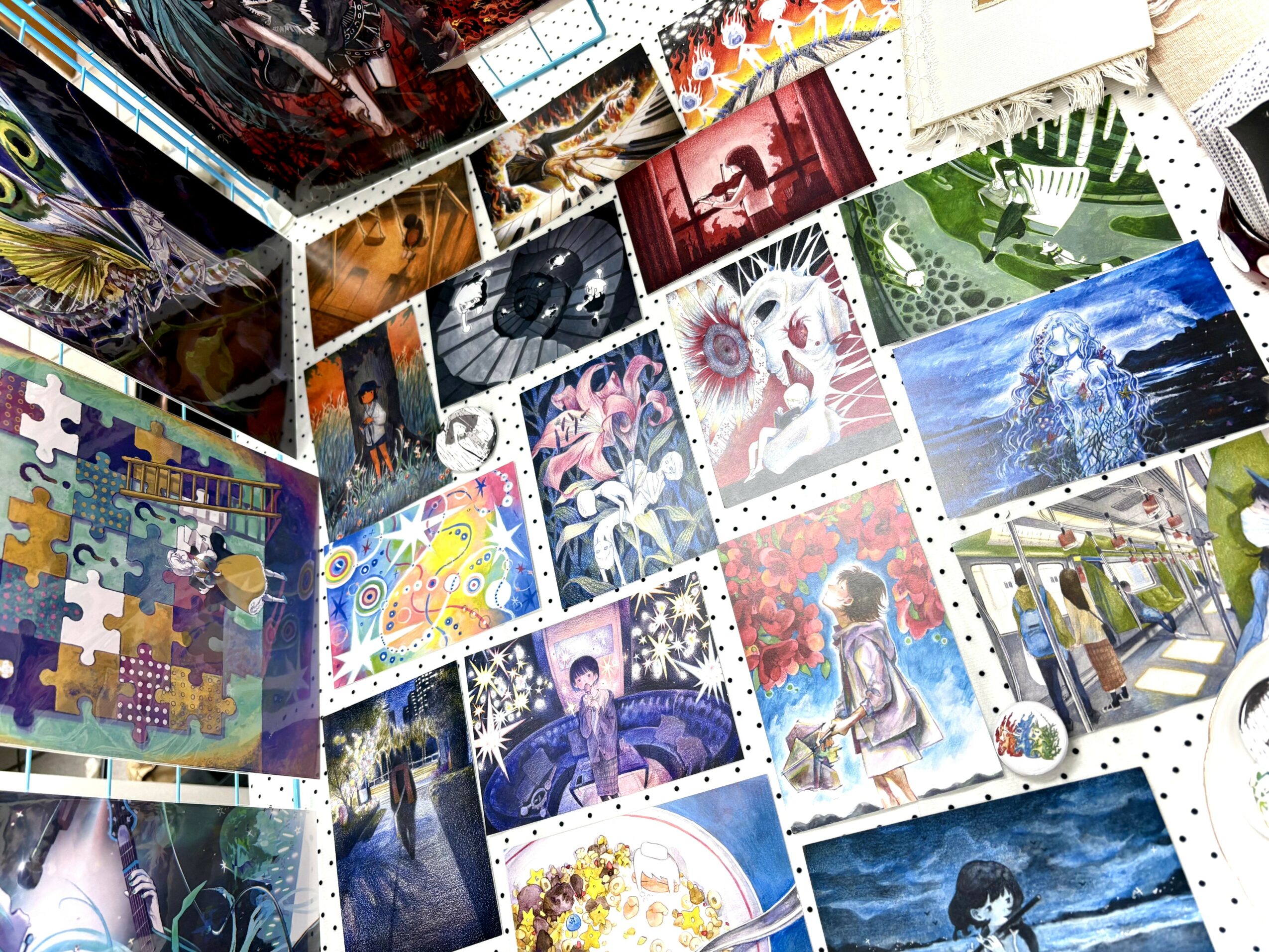 Collection of colorful jigsaw puzzles, paintings, and photographs arranged on a white surface.