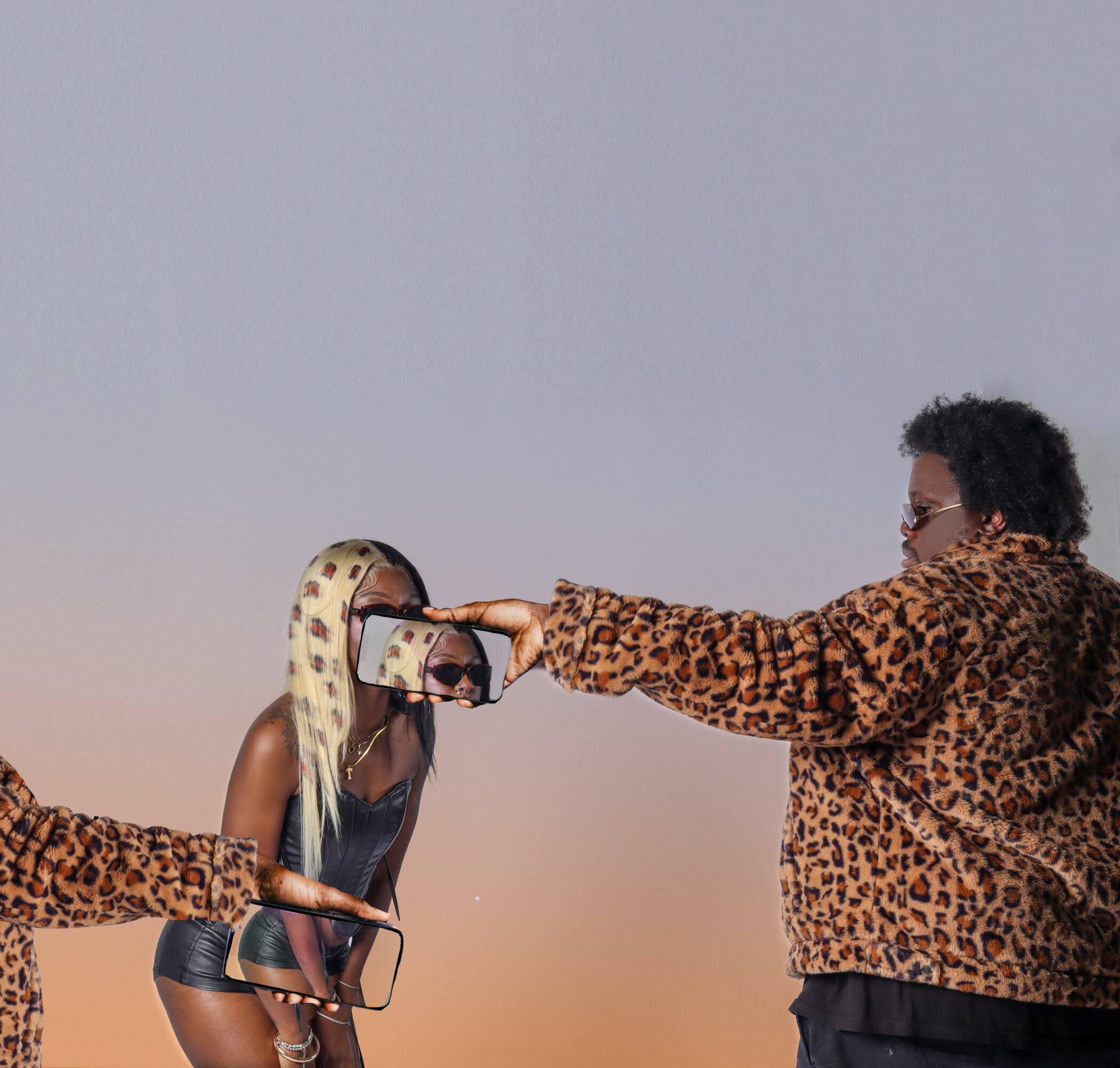 Person in leopard print jacket takes a selfie with a woman in black outfit, against a plain background.
