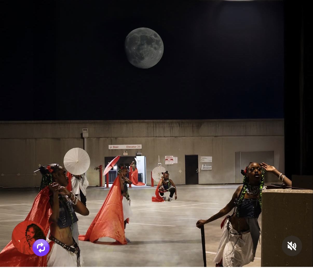People in costumes with props under a large moon on a dark sky, on a concrete surface, night scene.