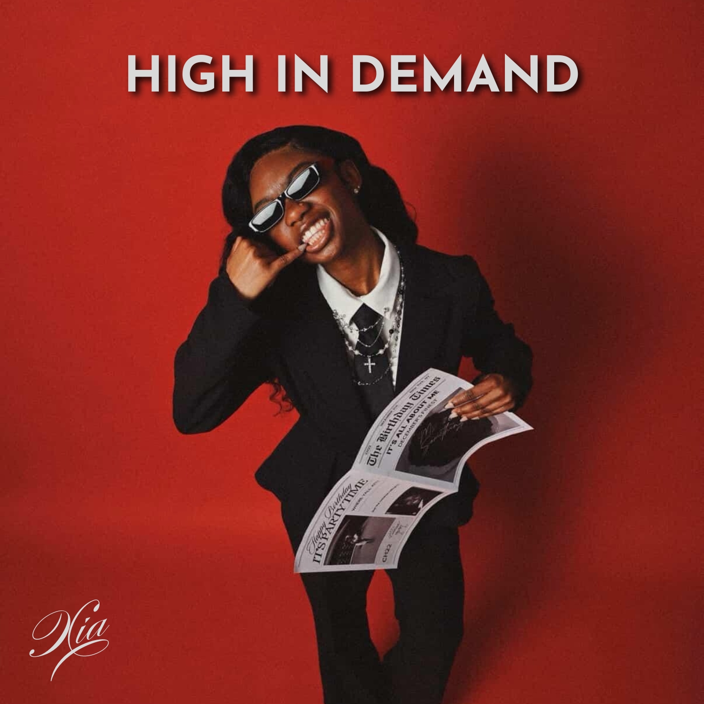 Smiling woman in black suit holding a newspaper, with text 'HIGH IN DEMAND' above her, against a red background.