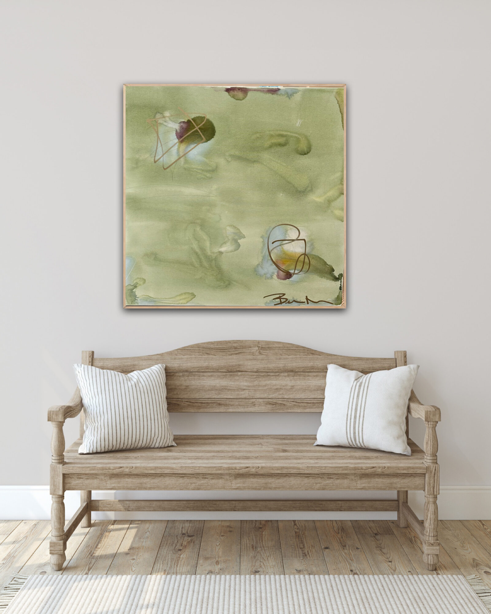 Wooden bench with two white pillows in front of a plain wall with a green abstract painting above.