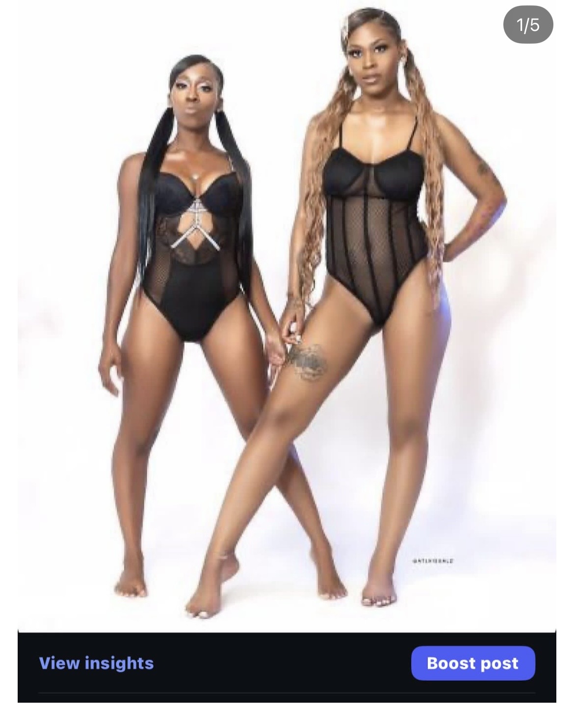 Two women in black lingerie pose against a white background, one with long braids and the other with straight hair.