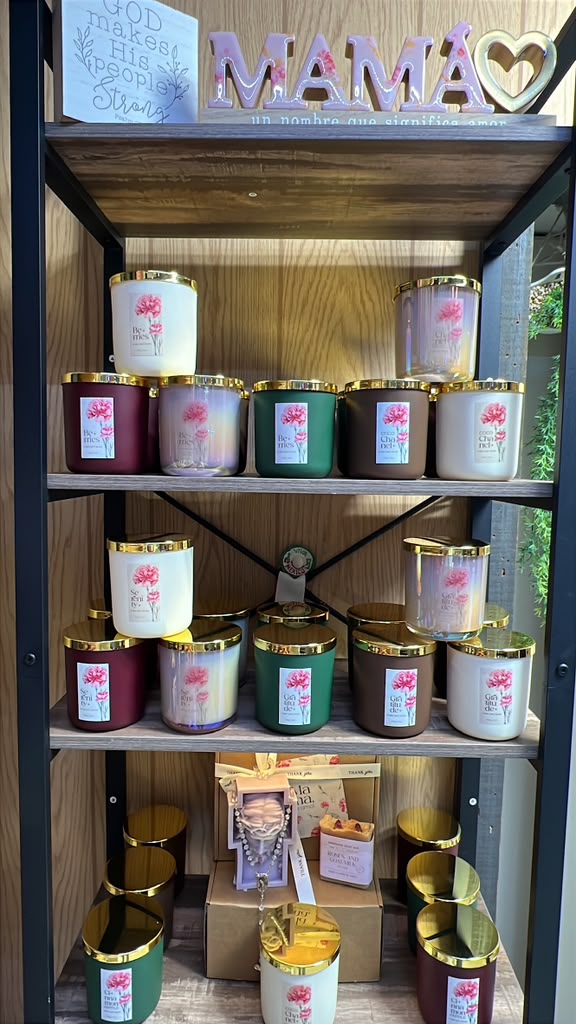 Shelf with candles, decorative signs, and gift boxes, with a wooden background and window on the right side.