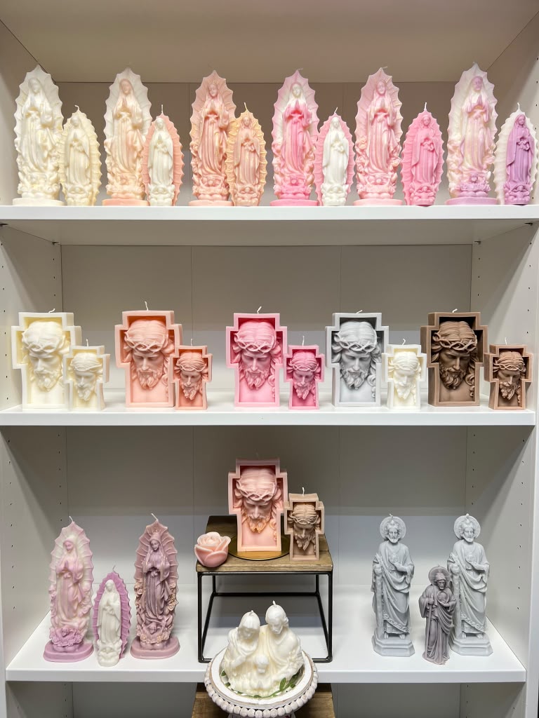 Shelves display various religious statues in pink, white, black, and beige, with some on small tables and a tray at the bottom.