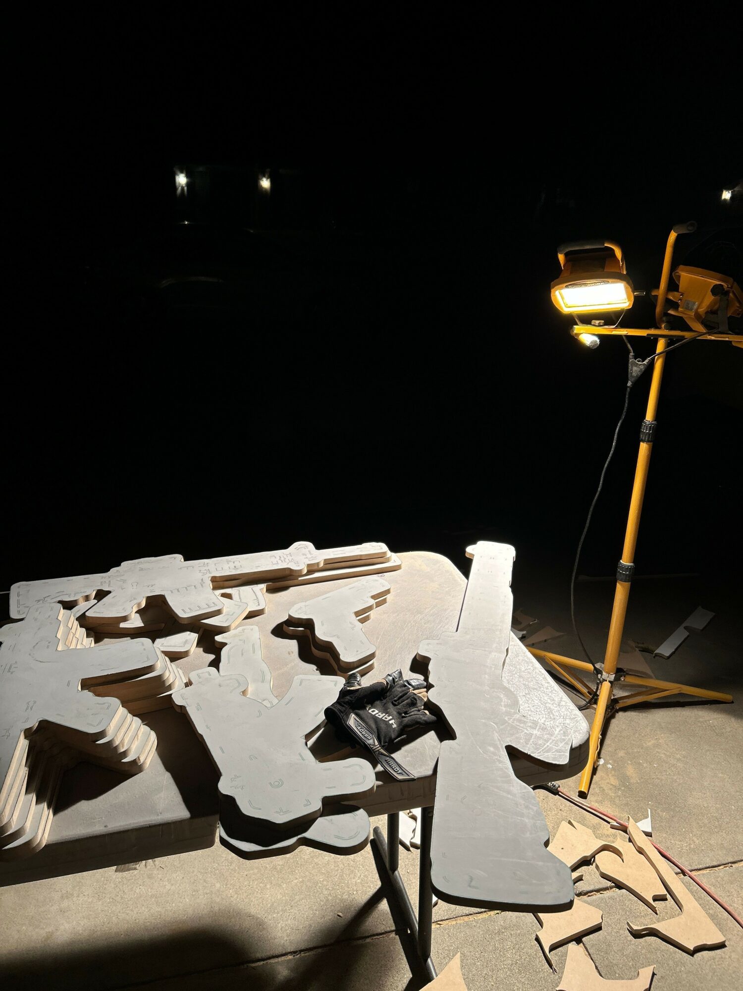 A broken concrete structure with a person lying on it, illuminated by a streetlight at night, with a car door open nearby.