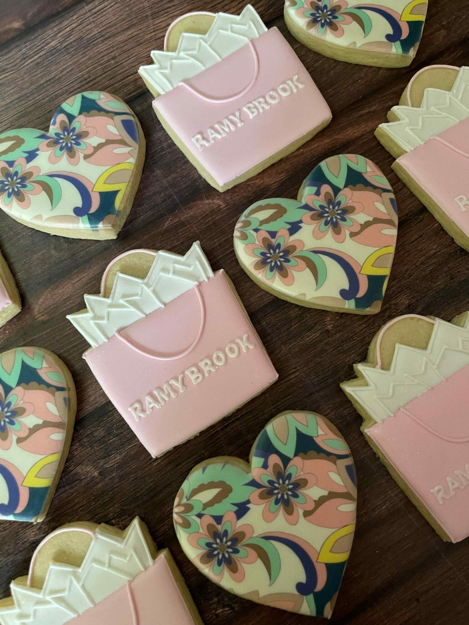 Decorative erasers shaped like hearts with floral patterns and pink erasers with white tips on a wooden surface.