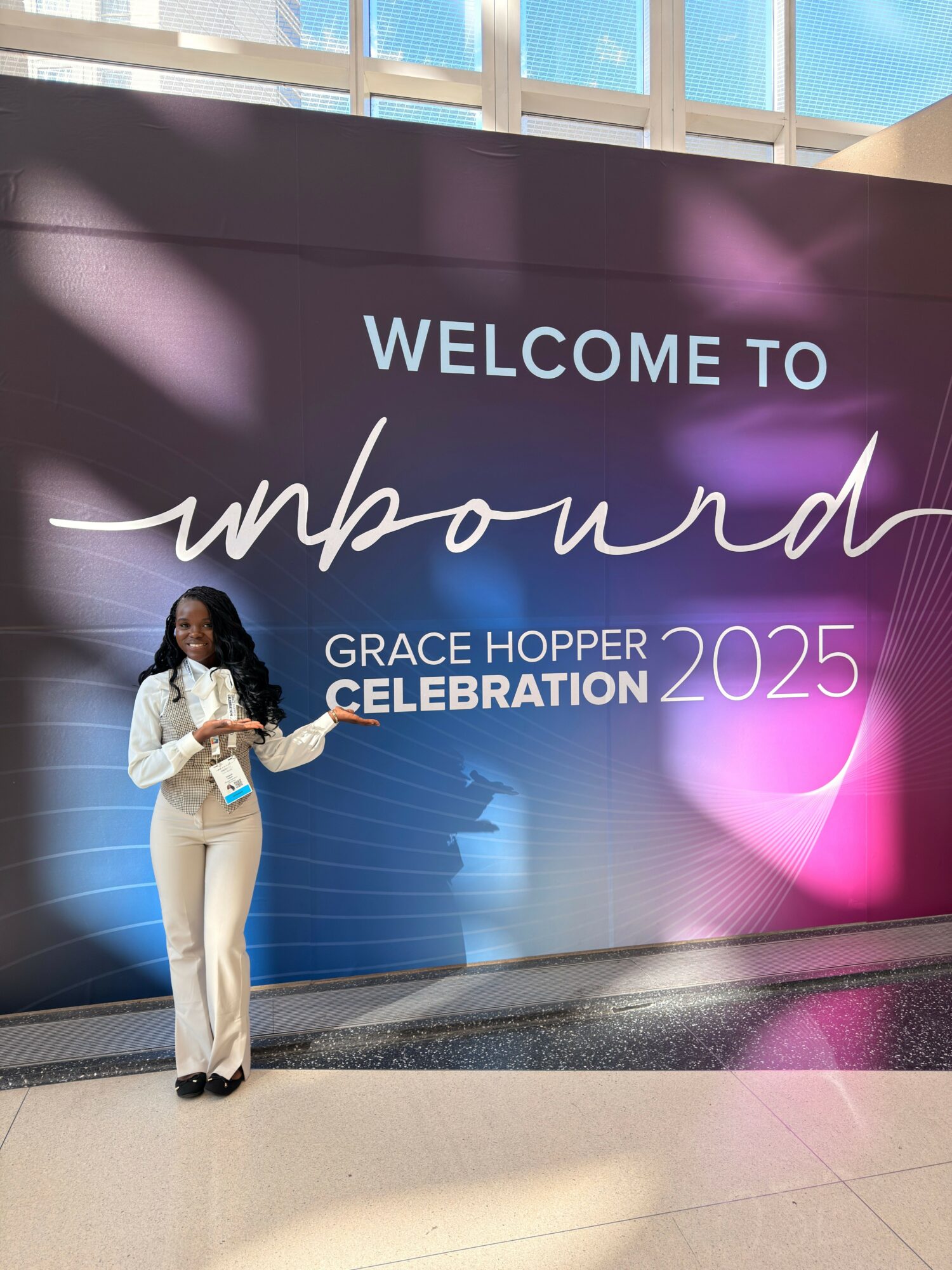 Person standing next to a large digital screen with welcoming message for a celebration in 2025.