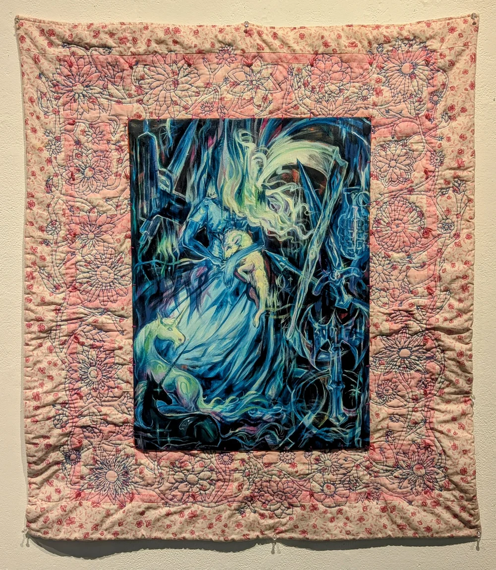 A quilt with a central fantasy scene featuring a blue and green dragon and a woman, surrounded by a pink floral border.