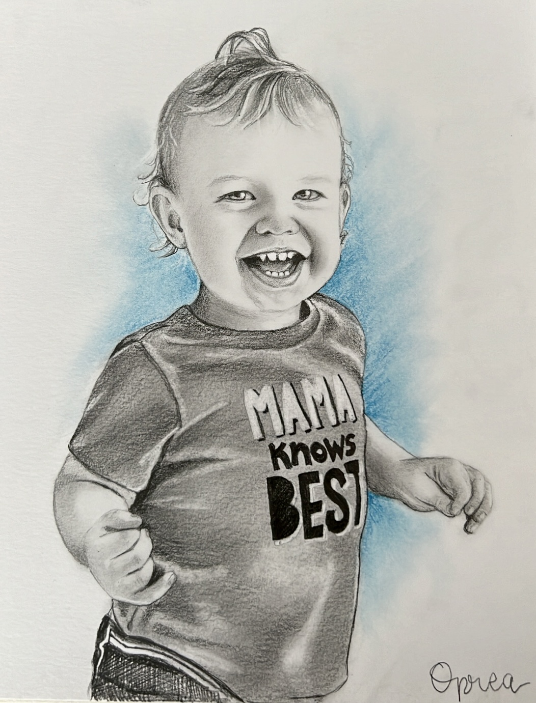Child with curly hair smiling, wearing a T-shirt with text, standing against a light background.