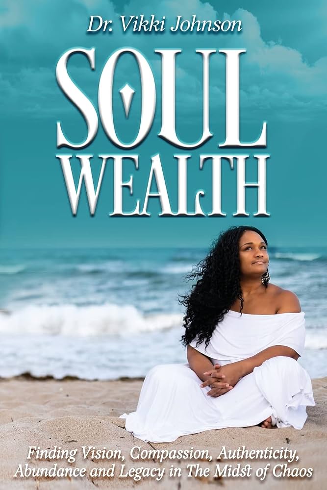 Woman sitting on beach sand with ocean waves behind her, wearing a white dress, looking upward, sky with clouds above.
