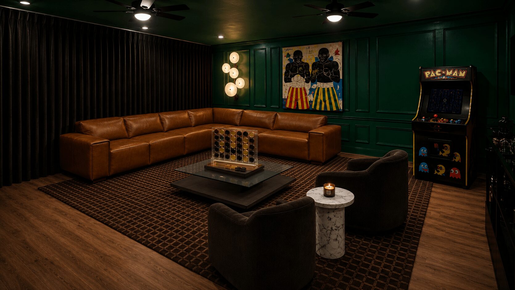 Living room with a large brown sectional sofa, dark walls, artwork, arcade game, and a coffee table with candles.
