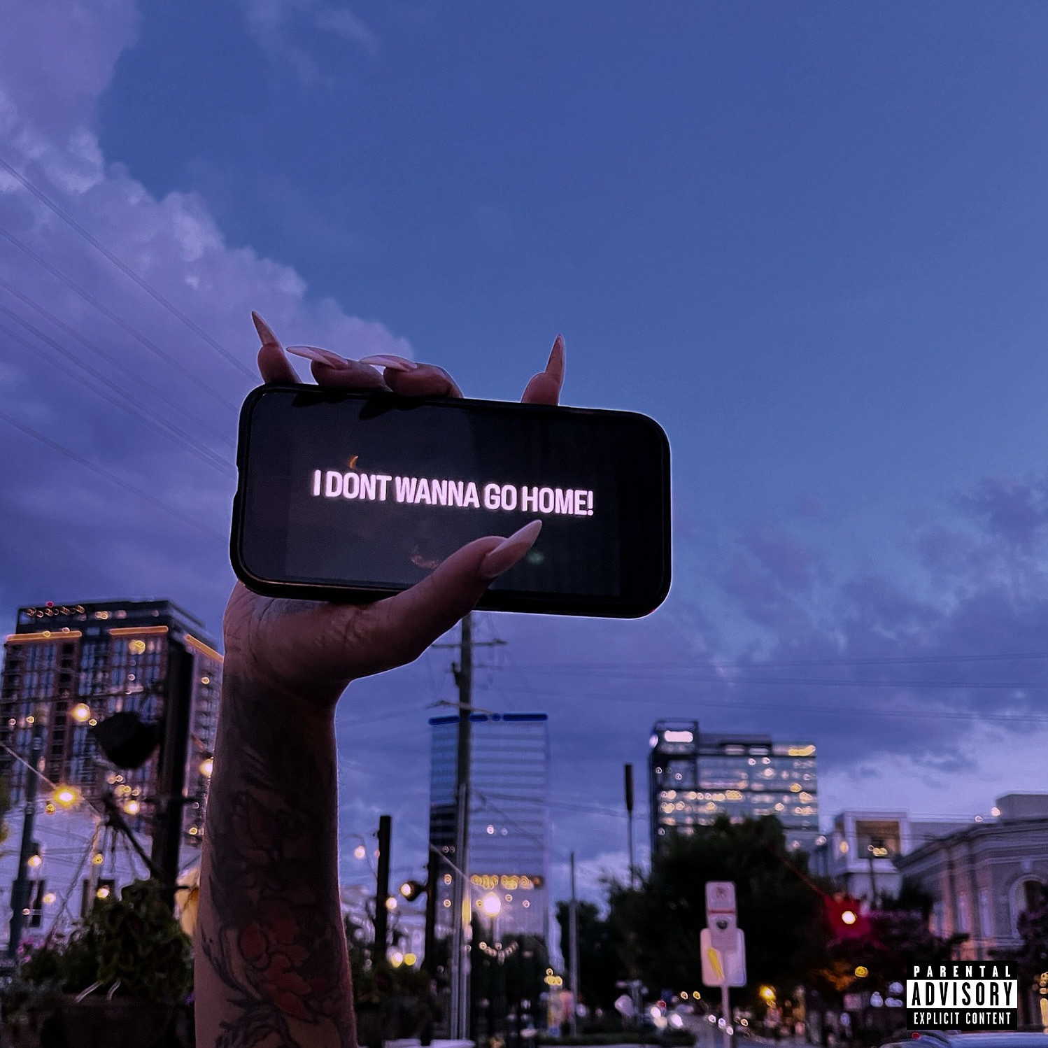 Person holding a phone with text, city skyline and evening sky in background.