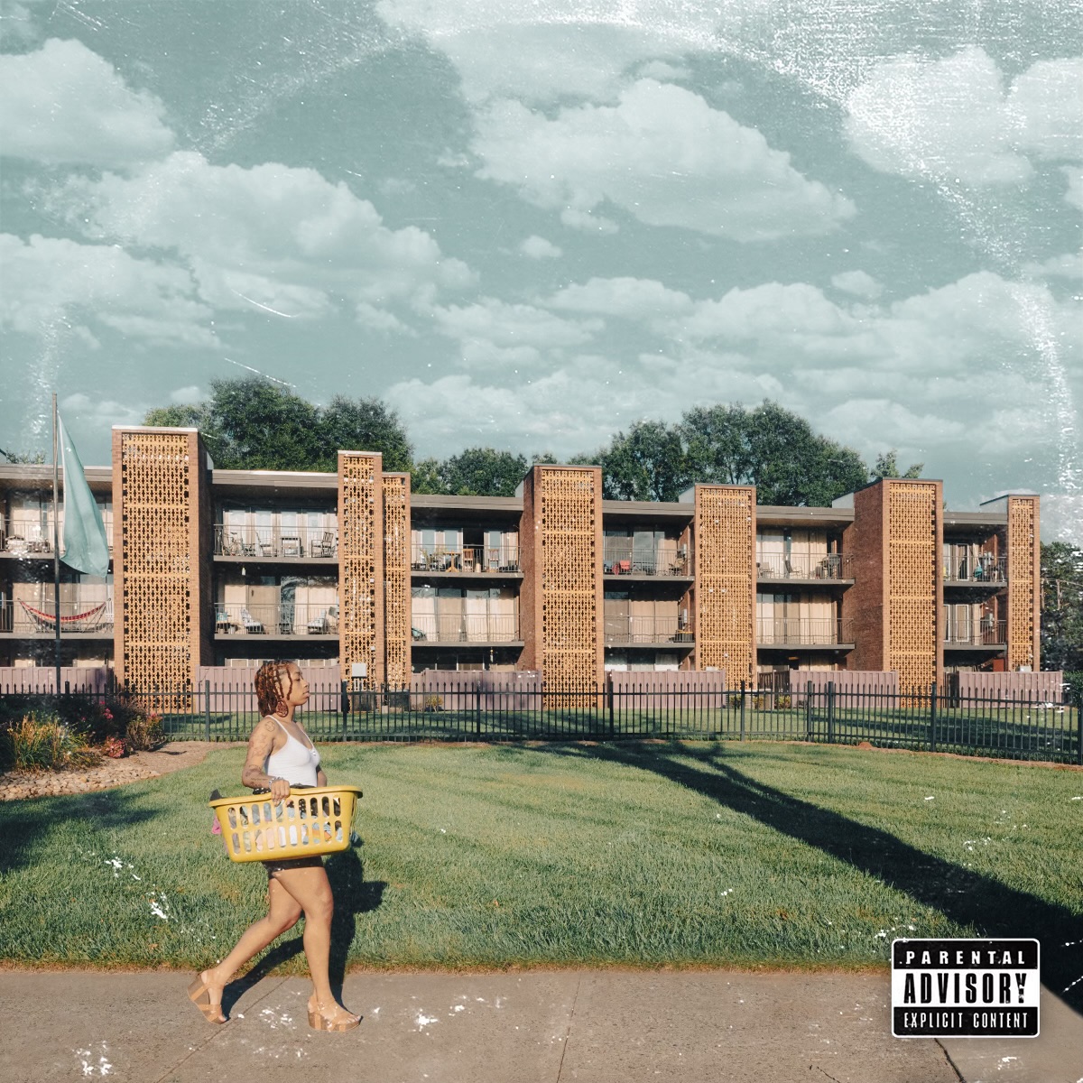 Young girl walking on sidewalk with a yellow basket, apartment building and cloudy sky in background.