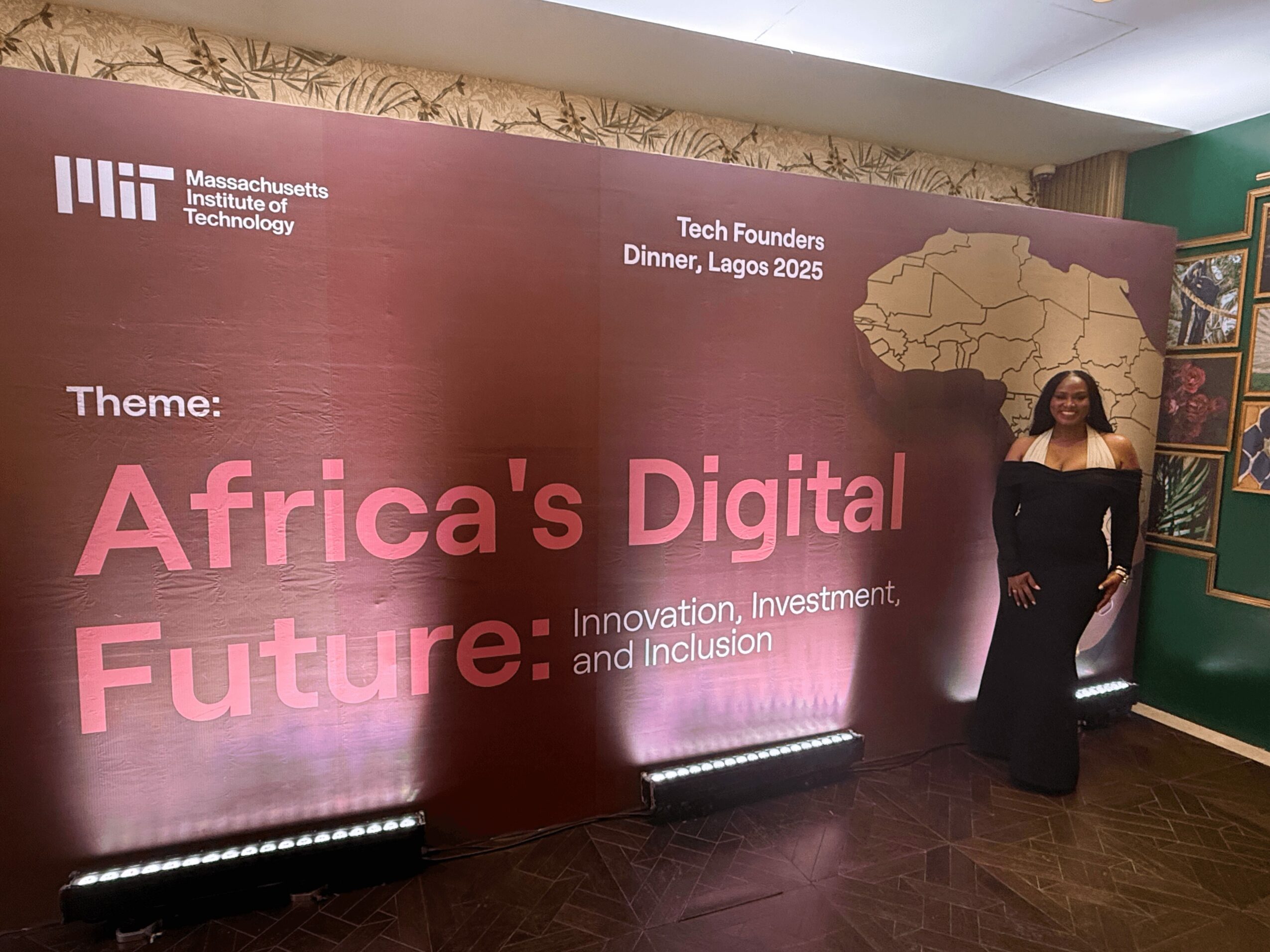 Woman in black dress standing next to a large maroon banner with text about Africa's digital future and a map of Africa.