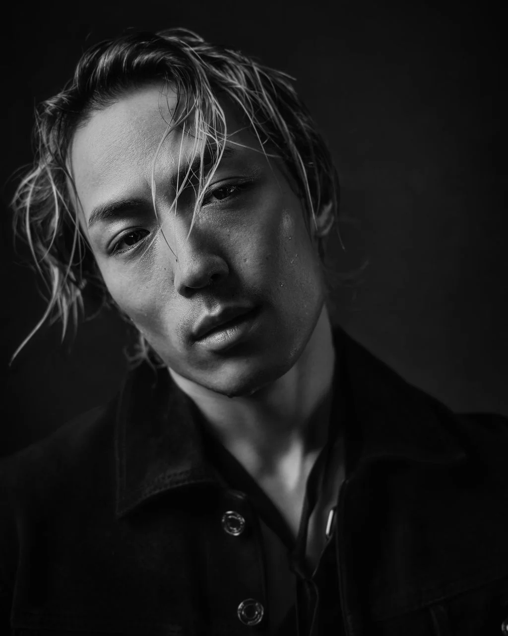 Portrait of a young person with wet hair, looking at the camera, in black and white.