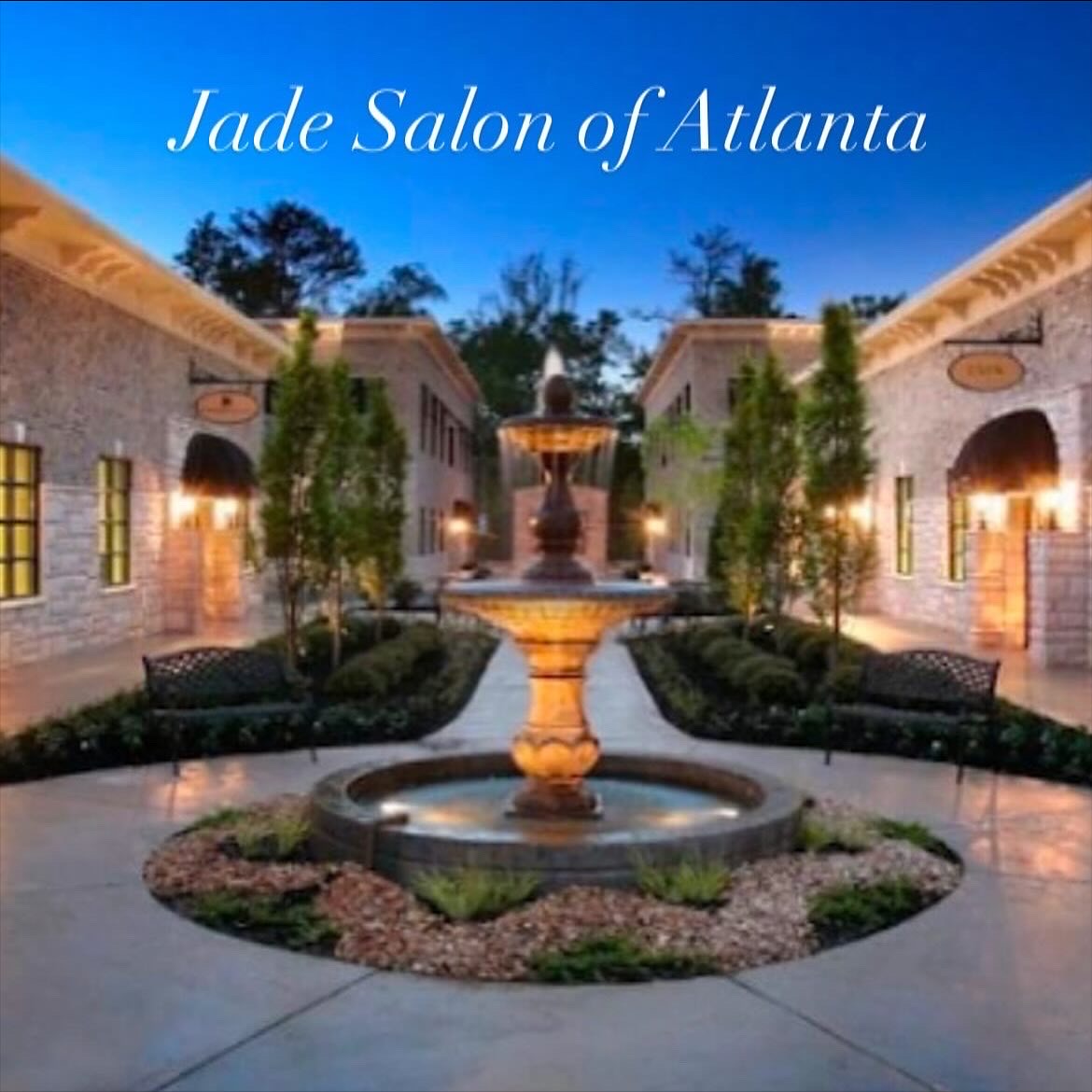 Elegant courtyard with fountain, trees, and buildings, with text 'Jade Salon of Atlanta' at the top, during evening or night.