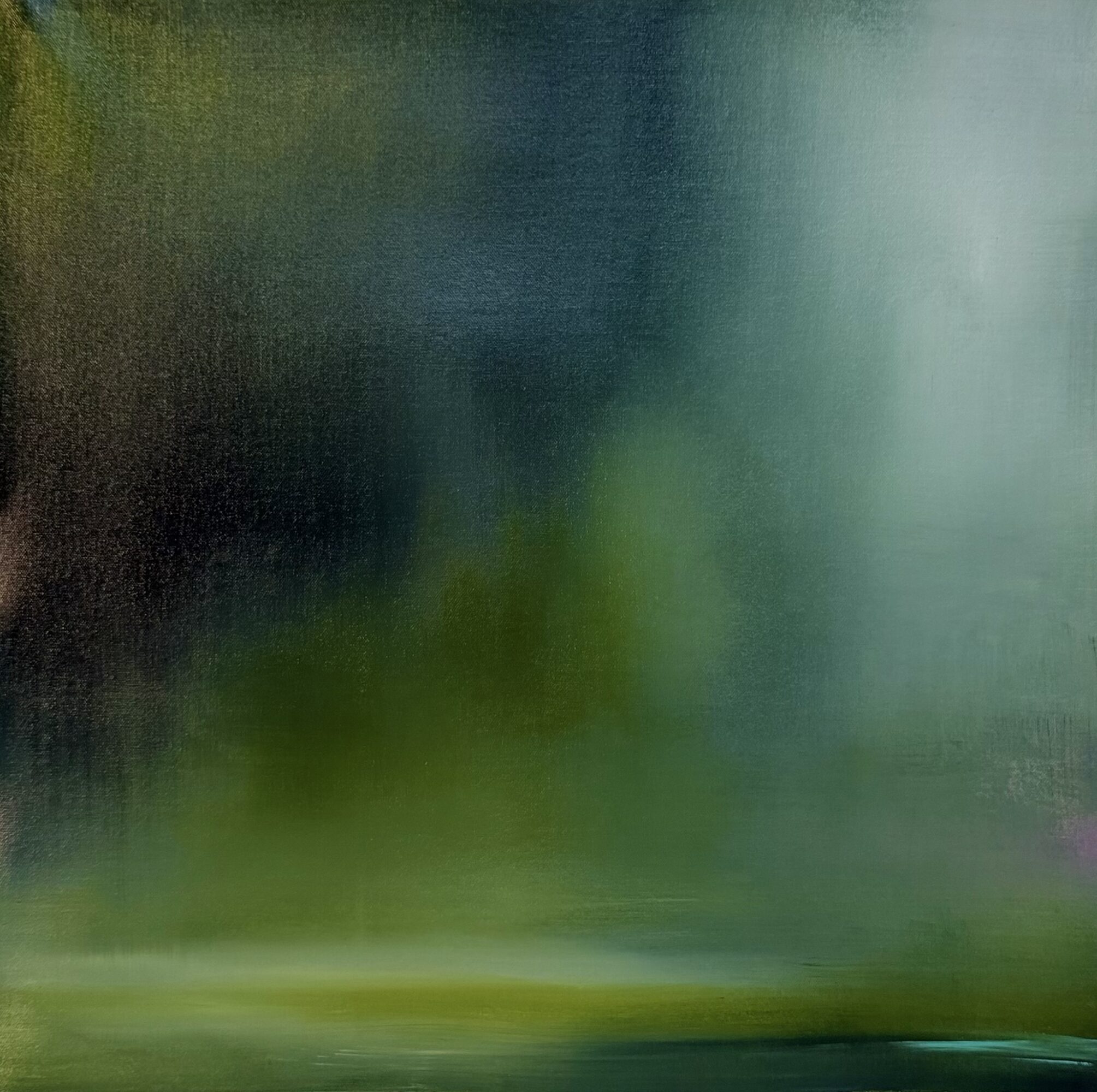 Blurred green and blue landscape with water reflection, no distinct objects visible.