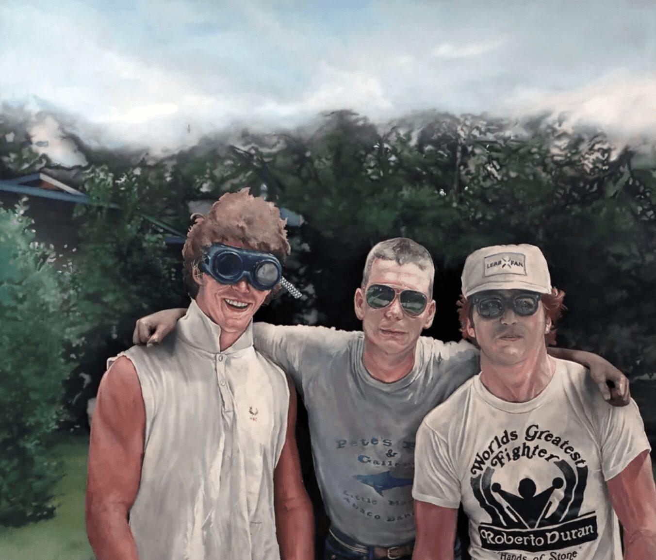 Three people standing outdoors, two wearing sunglasses, one with a cap, with trees and cloudy sky in background.