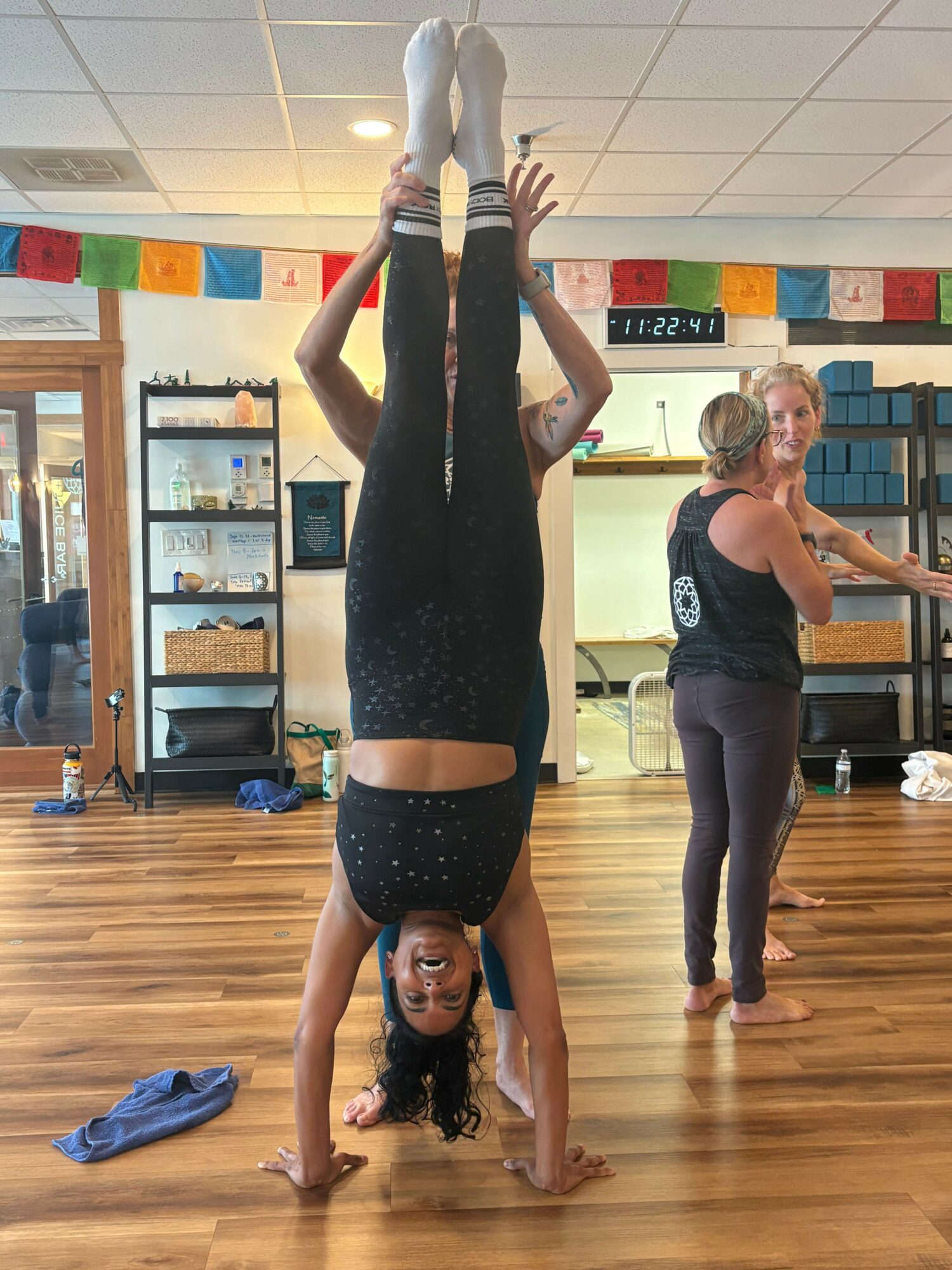 Two women in a dance studio, one lying on the floor and the other standing, both in dance poses.