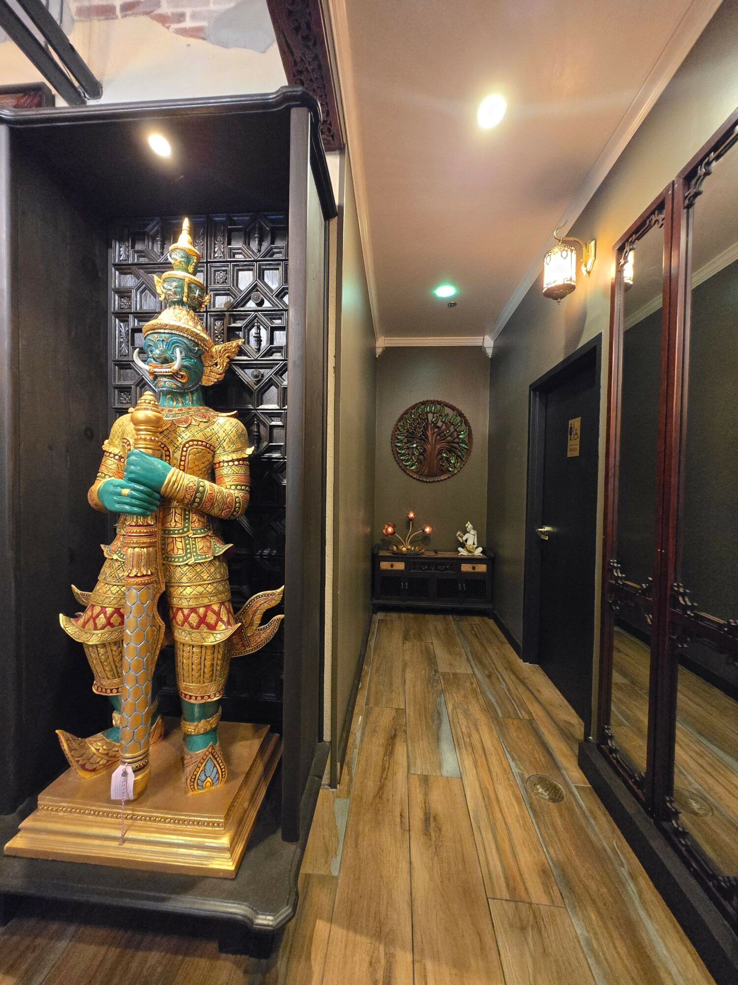 A colorful statue of a deity or mythological figure inside a shrine, with intricate details and gold accents.