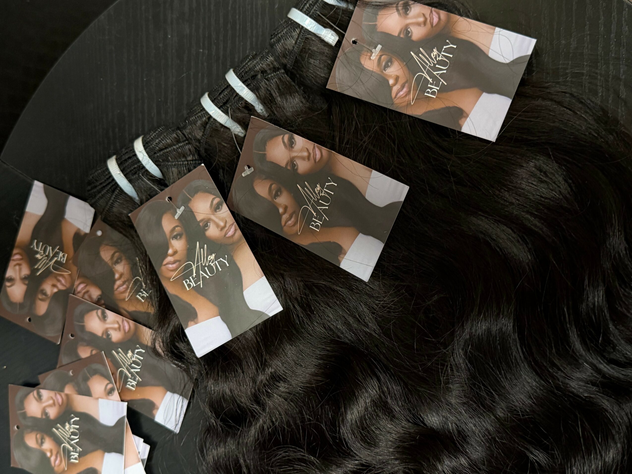 Multiple hair extension or wig samples with labels on a black surface.