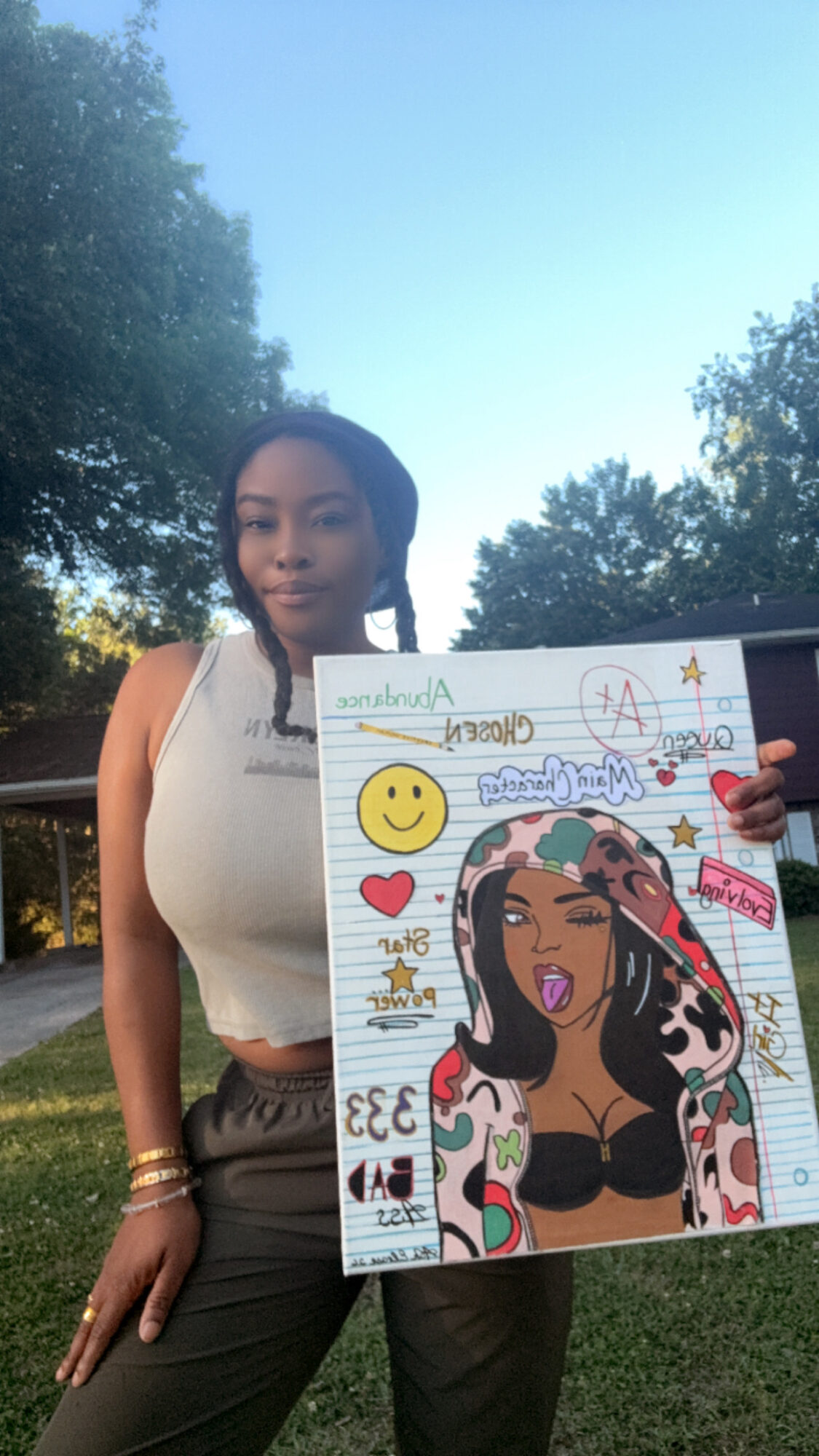 Young woman holding a colorful drawing outdoors with trees and blue sky in background.