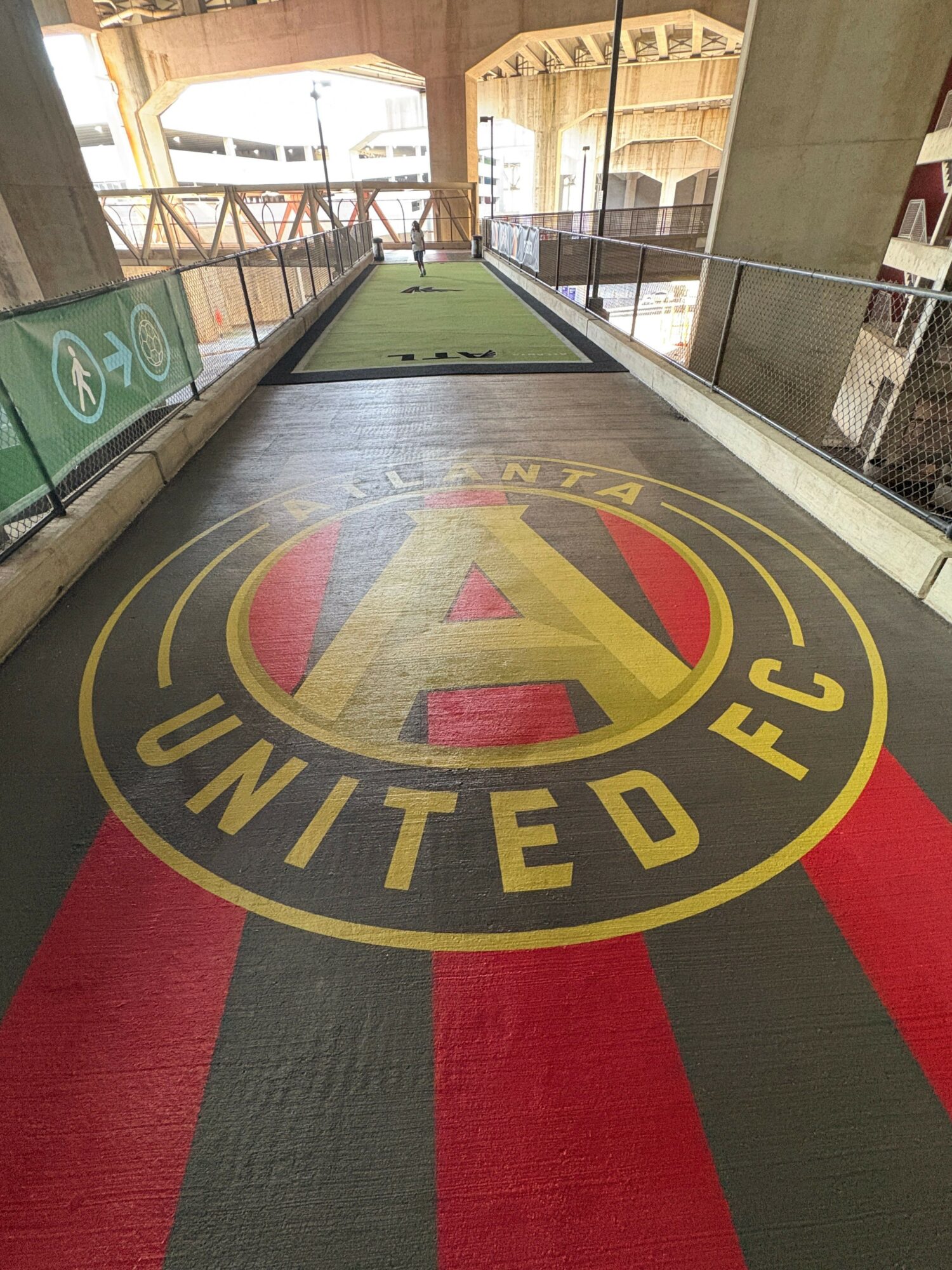 Indoor sports facility with a large logo on the floor reading 'EDITION FC' and a green playing surface.