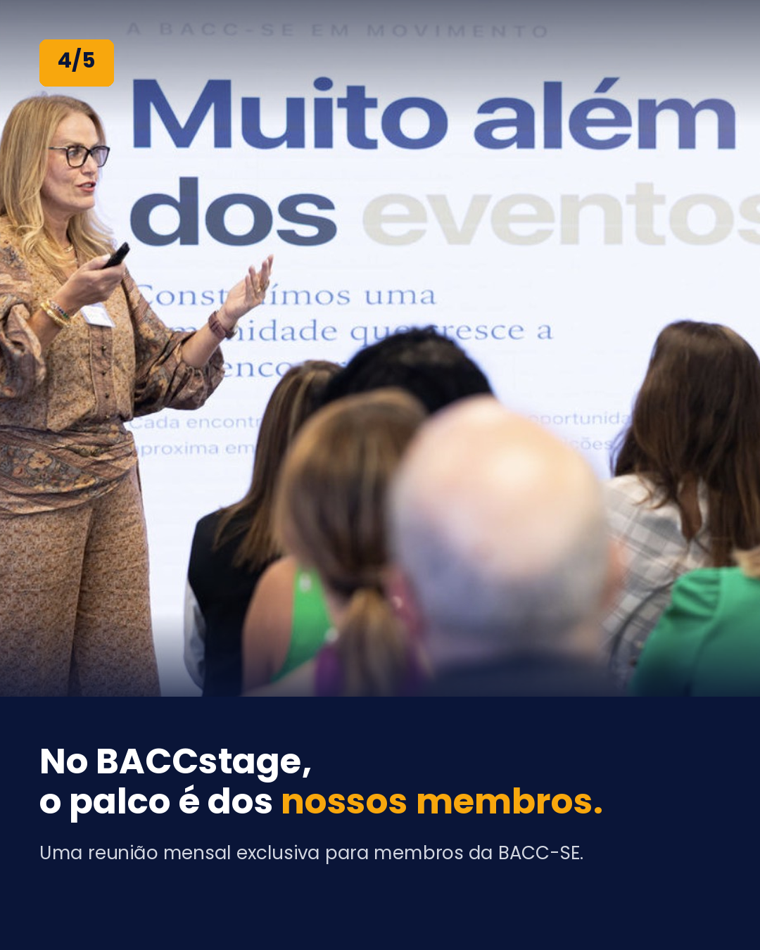 Woman speaking to an audience in front of a presentation slide with text in Portuguese, audience members visible from behind.