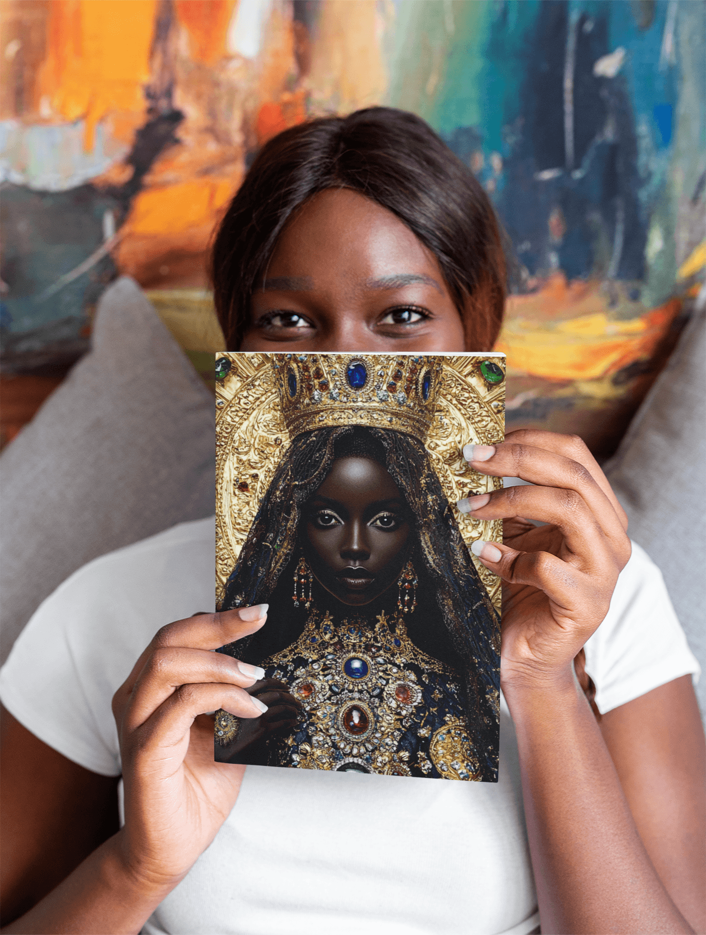 Person holding a book with a portrait of a woman wearing ornate jewelry, partially covering their face, in front of colorful abstract background.