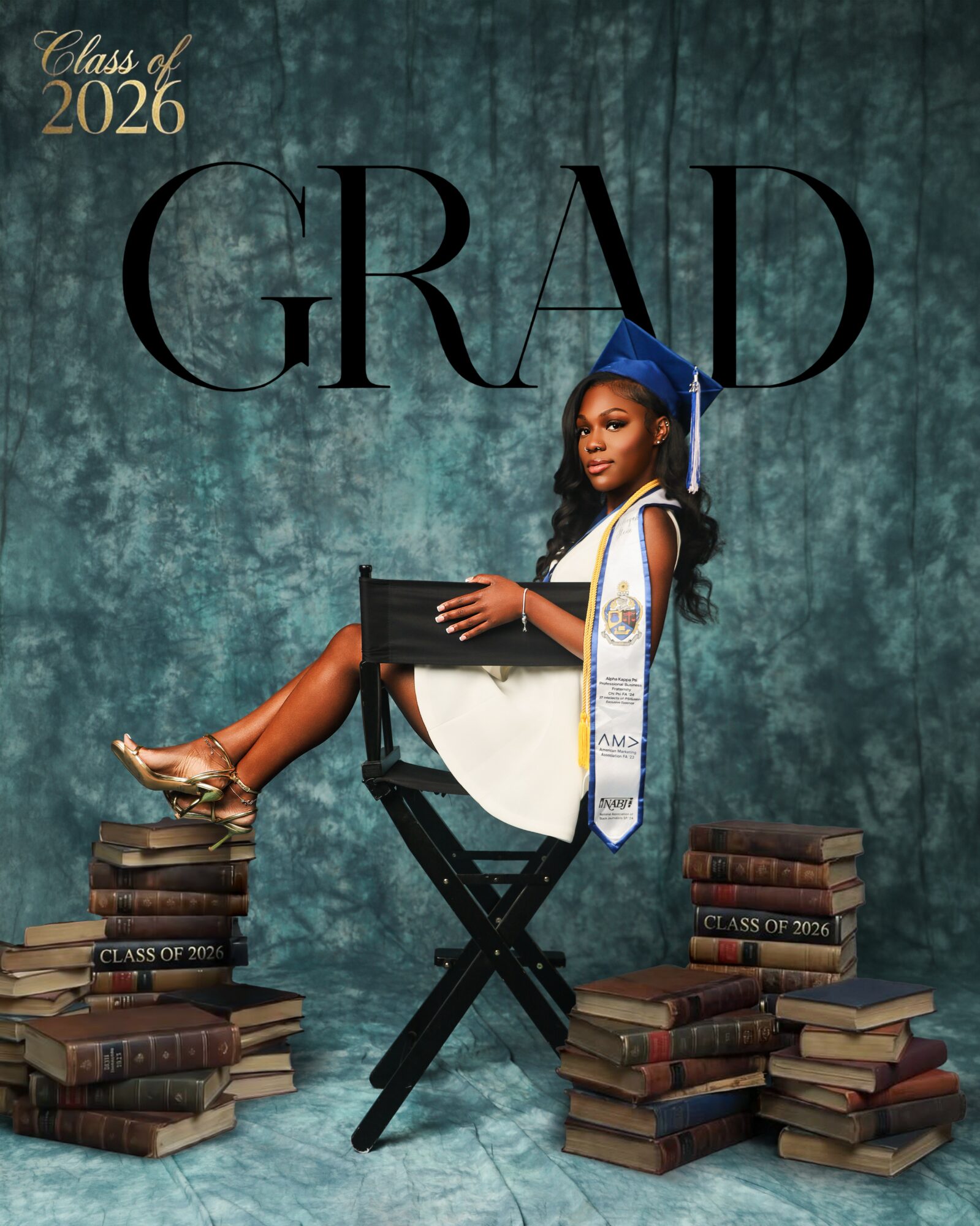 Young woman in graduation cap and gown sitting on a chair, surrounded by stacks of books, with a textured blue background.