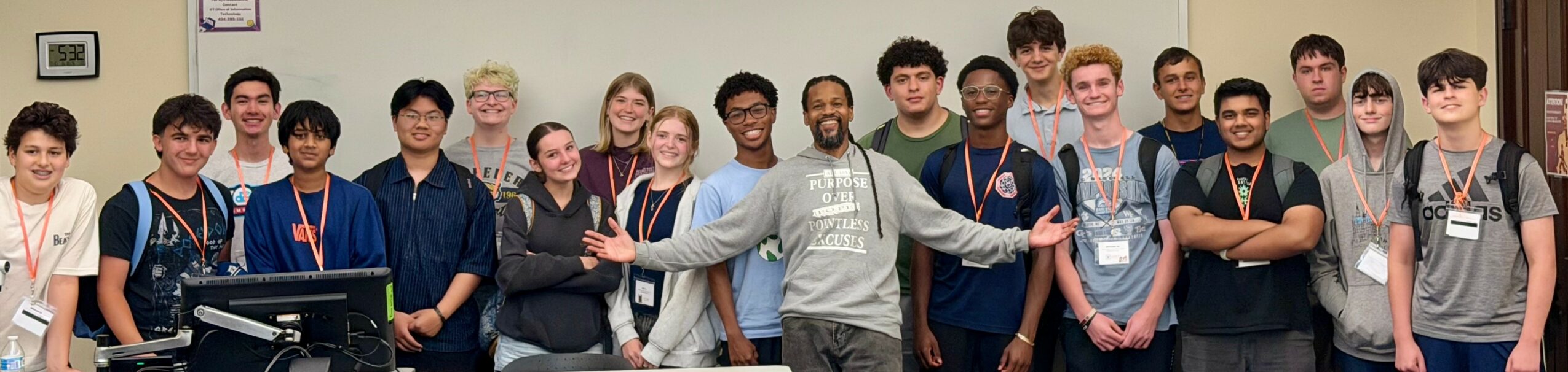Group of diverse students and teachers standing together in a classroom or school setting.