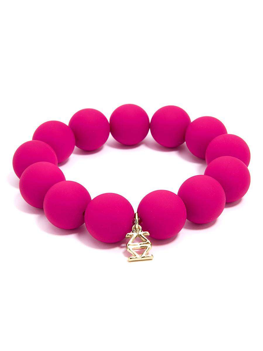 Pink beaded bracelet with a small gold charm, arranged in a circle on a white background.