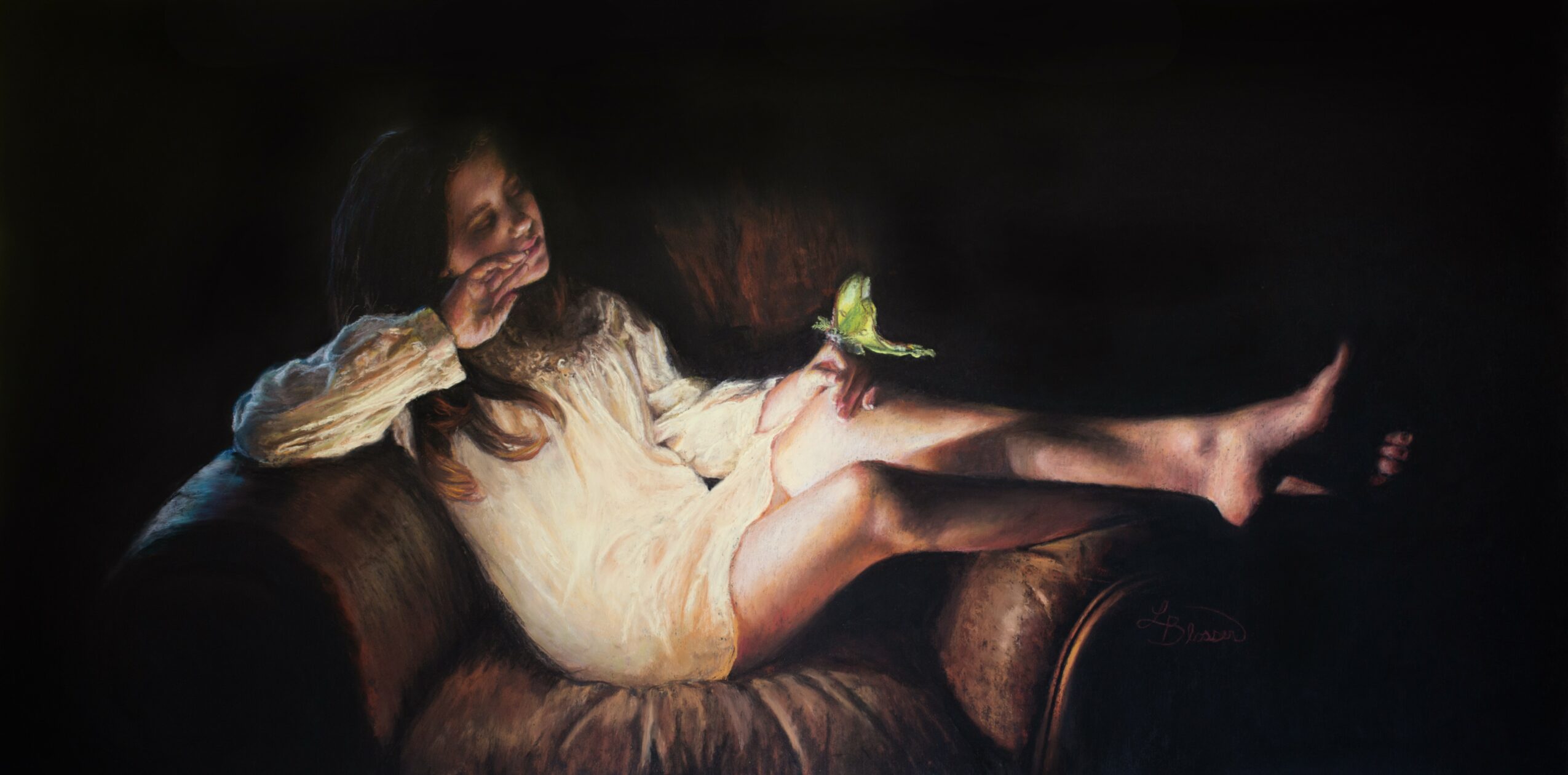 Young girl lying on a couch, holding a small green object, with long hair and a light-colored dress, in a dark background.