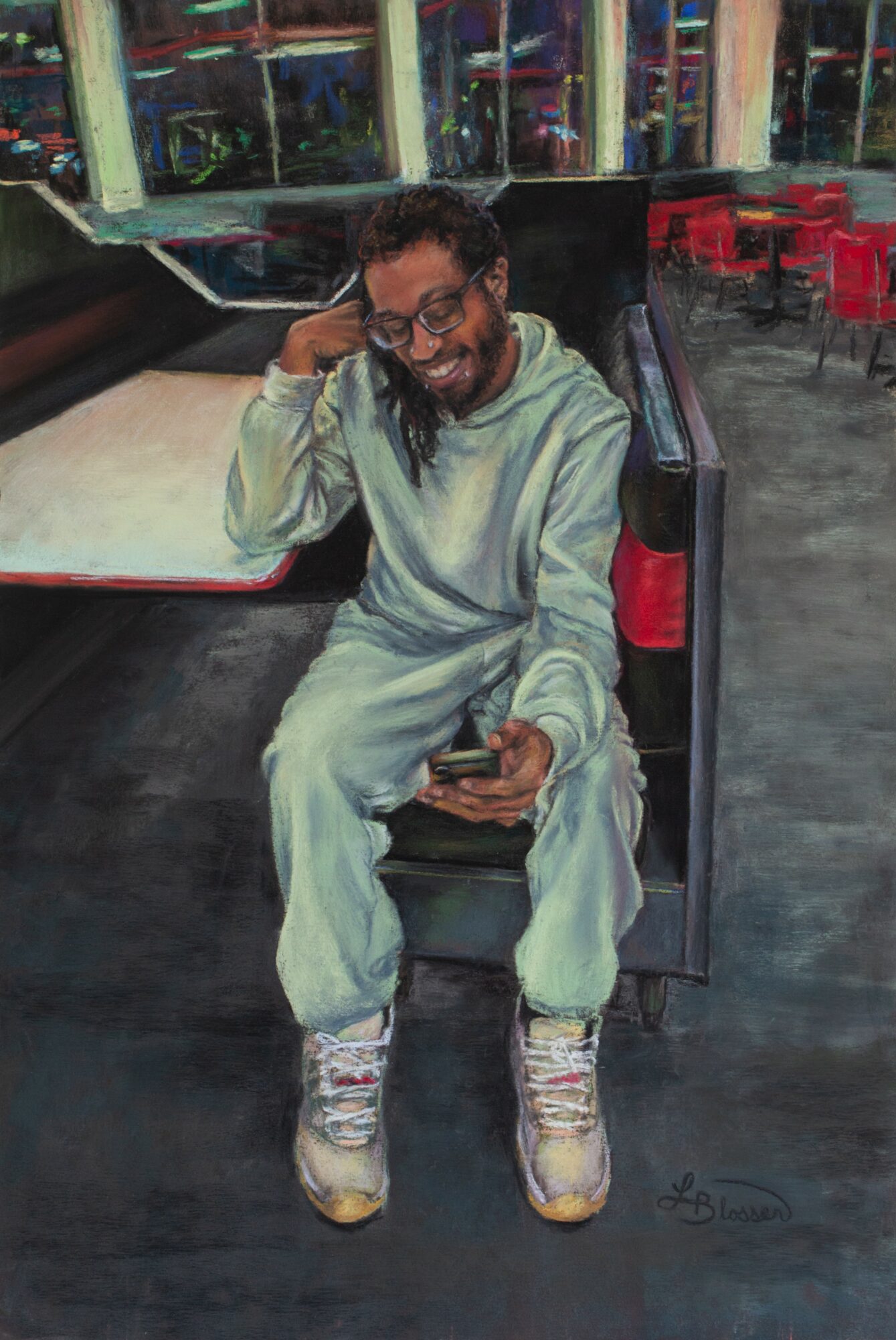 Person sitting on a bench, smiling, holding a phone, wearing light-colored clothing and sneakers, in an indoor setting.