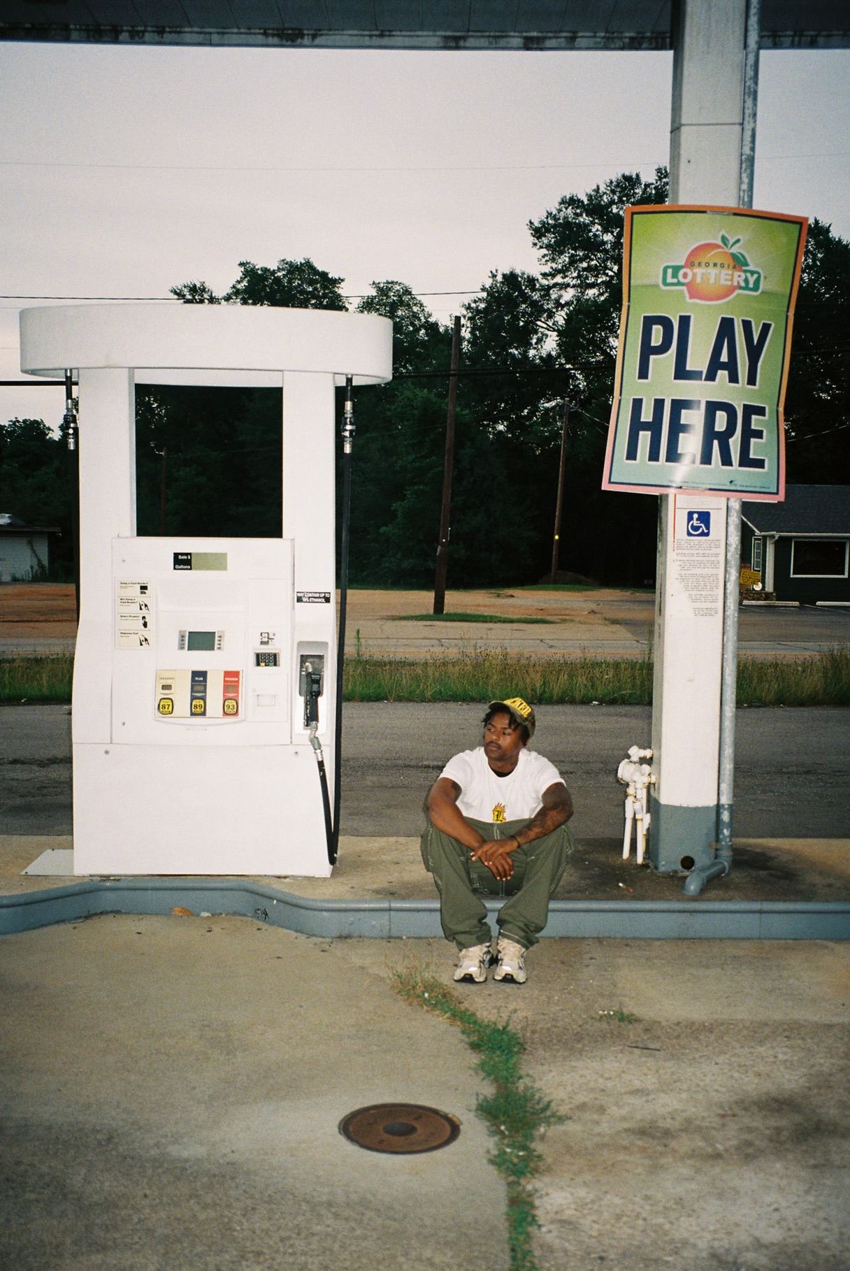 Child walking past a pay station with a sign that says 'Play Fire' in a parking lot.