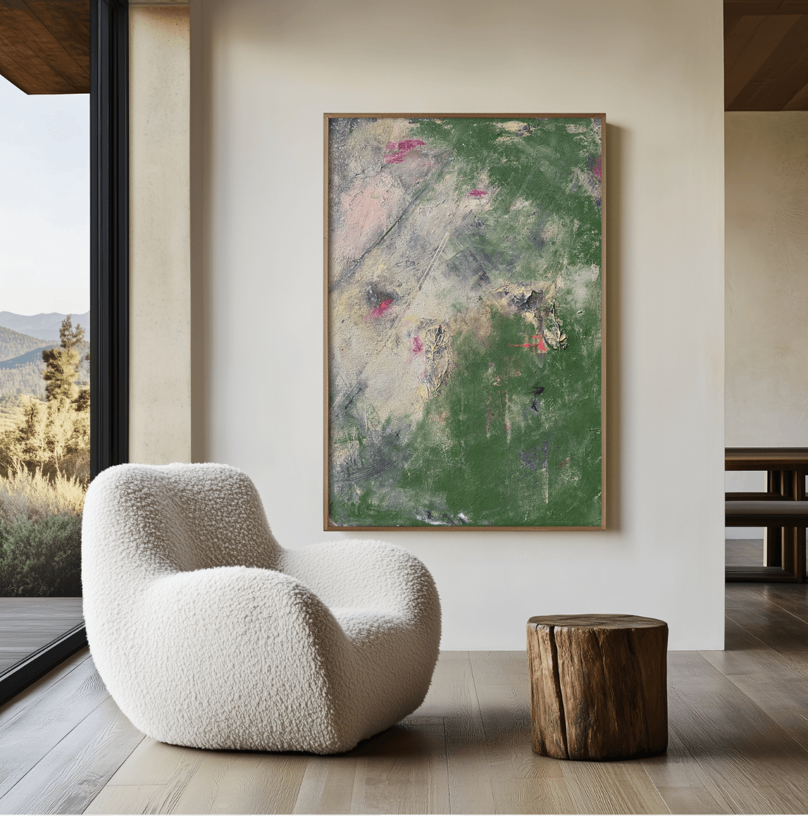 Abstract painting with green, pink, and white colors on a wall, cream textured armchair, and wooden stool in a modern room.