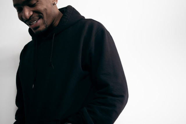 Person wearing a black hoodie, smiling, with a white background.