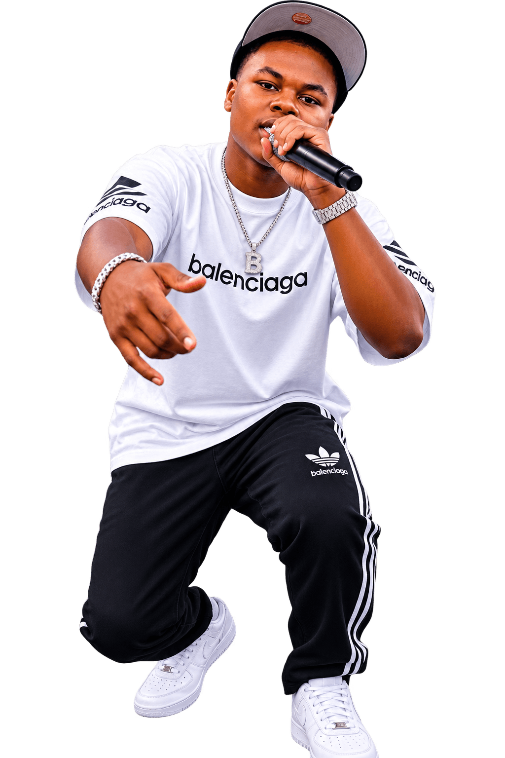 Young man in a white Balenciaga t-shirt and black Adidas pants, holding a microphone, performing on stage.