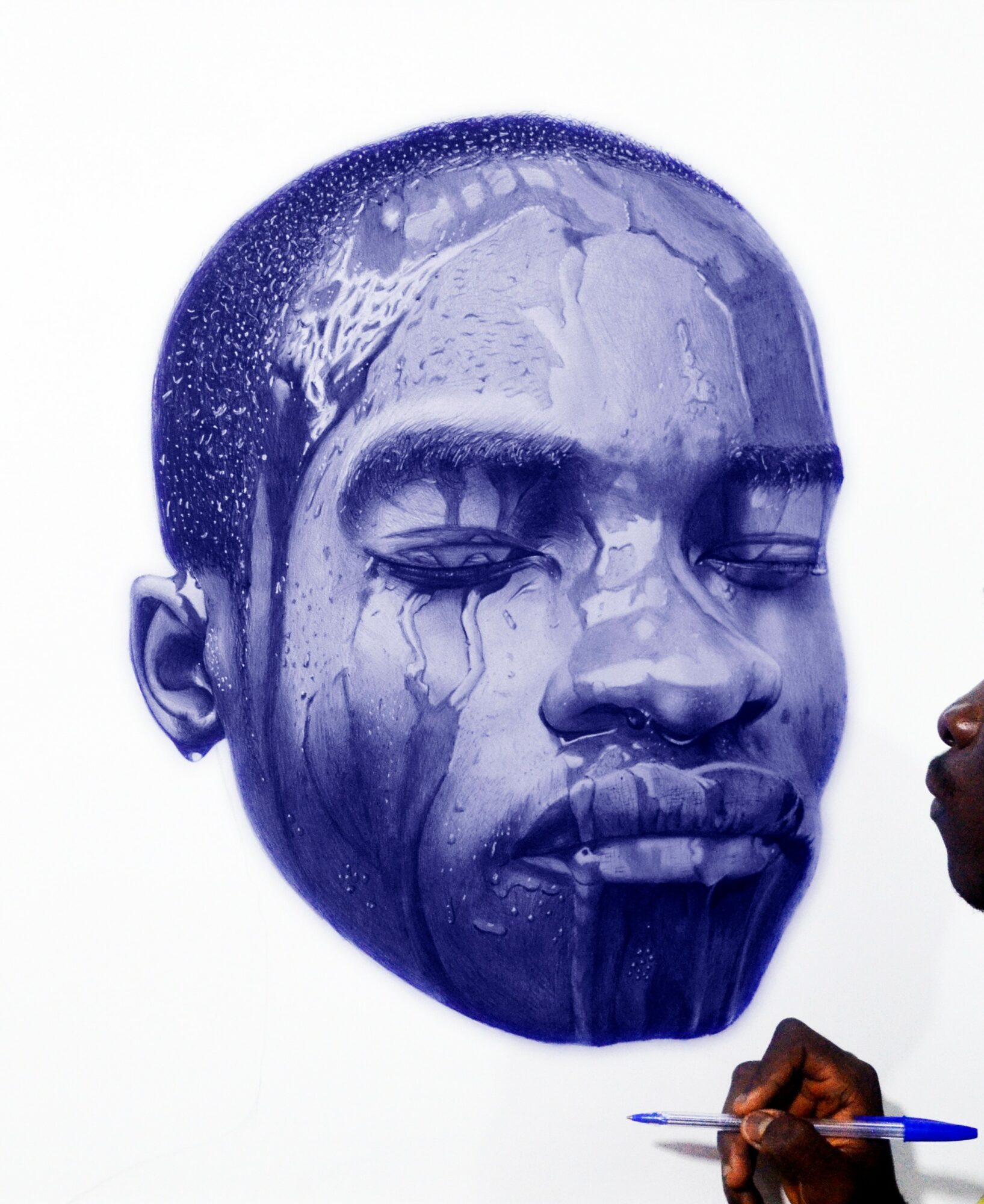 A blue painted face with closed eyes and water streaks, on a white background.
