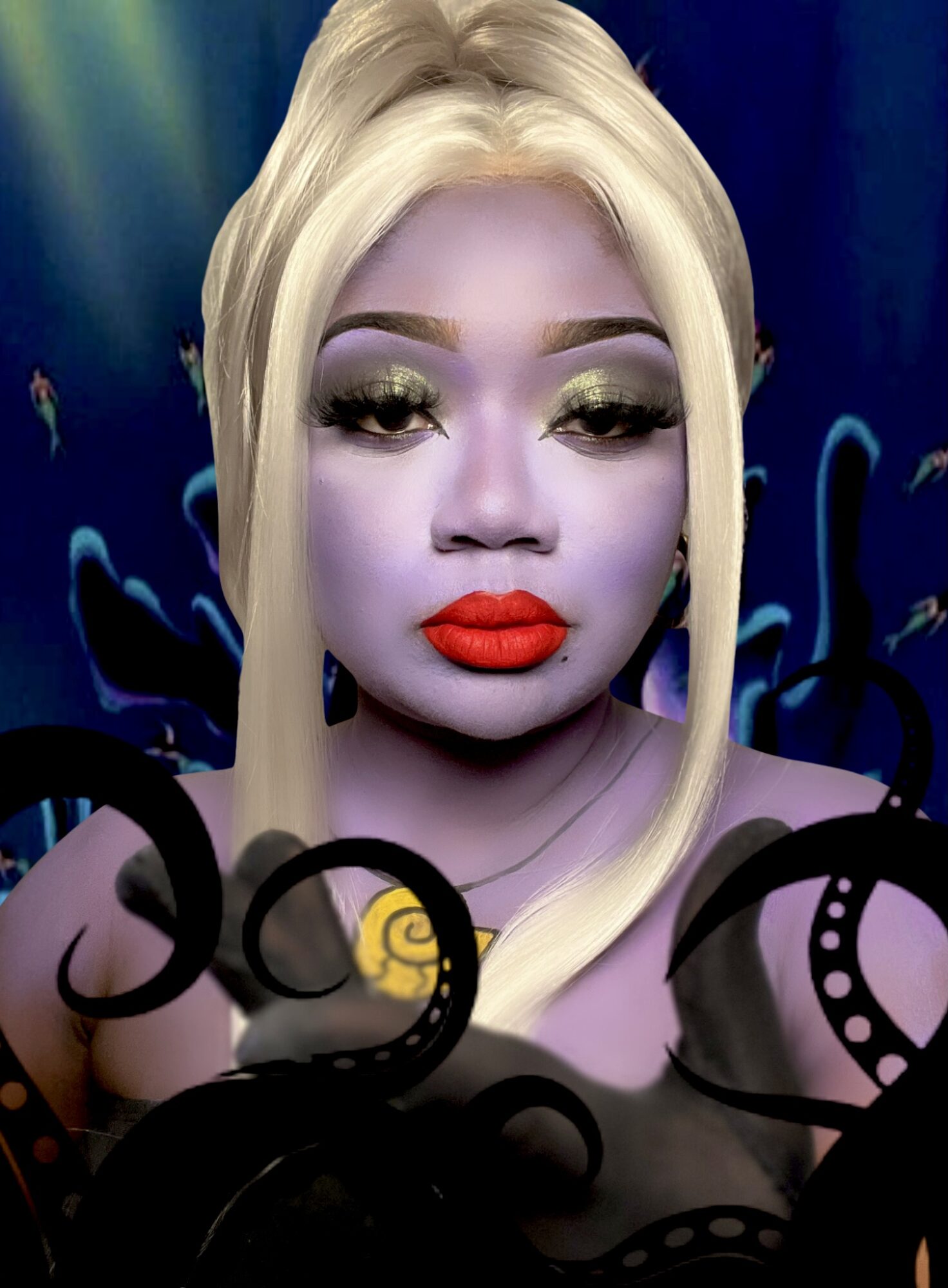 Person with blonde hair, makeup, and red lipstick, surrounded by black decorative elements, against a dark background.