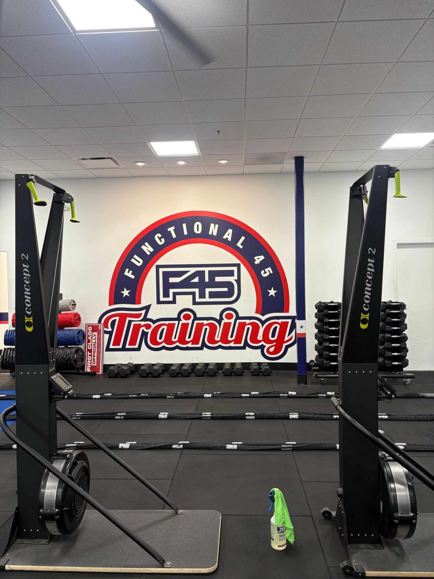 Gym equipment with a large wall logo reading 'F45 Training' and 'Functional 45' in a fitness center.