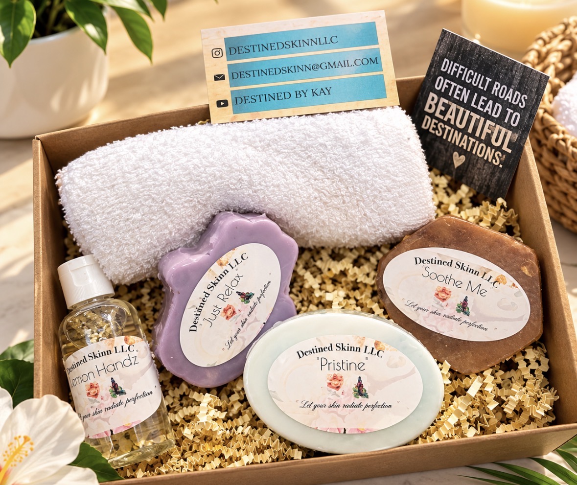 Box contains skincare products, a towel, and business cards, with a plant and flowers nearby.