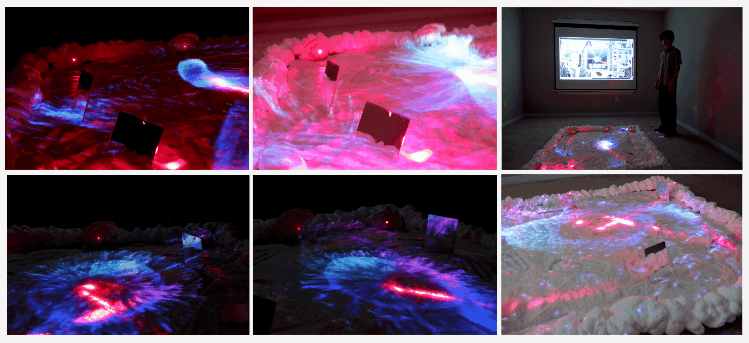 Person standing near a projected display on the floor with colorful light effects, in a dark room.