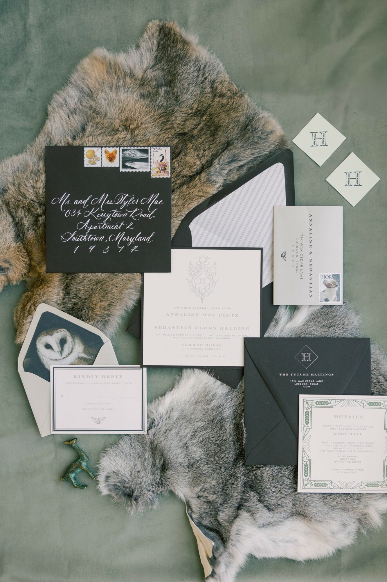 Flat lay of wedding invitations and stationery on a fur background, including cards, envelopes, and tags.