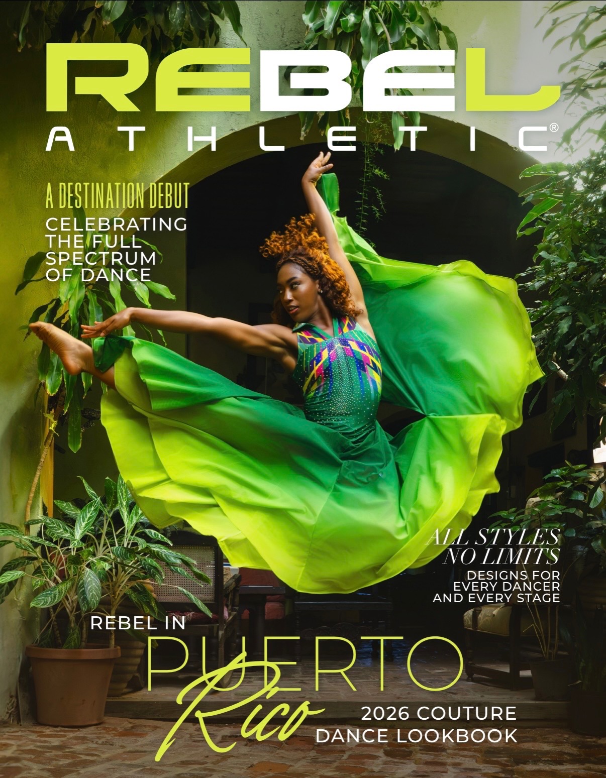 Dancer in a colorful dress and flowing green skirt performs outdoors among plants and trees.