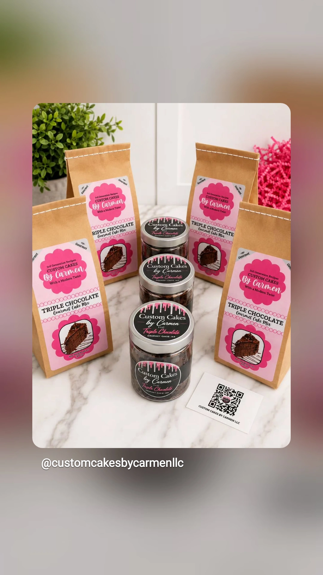 Display of small jars and pink and brown packaging on a white surface with a plant in the background.