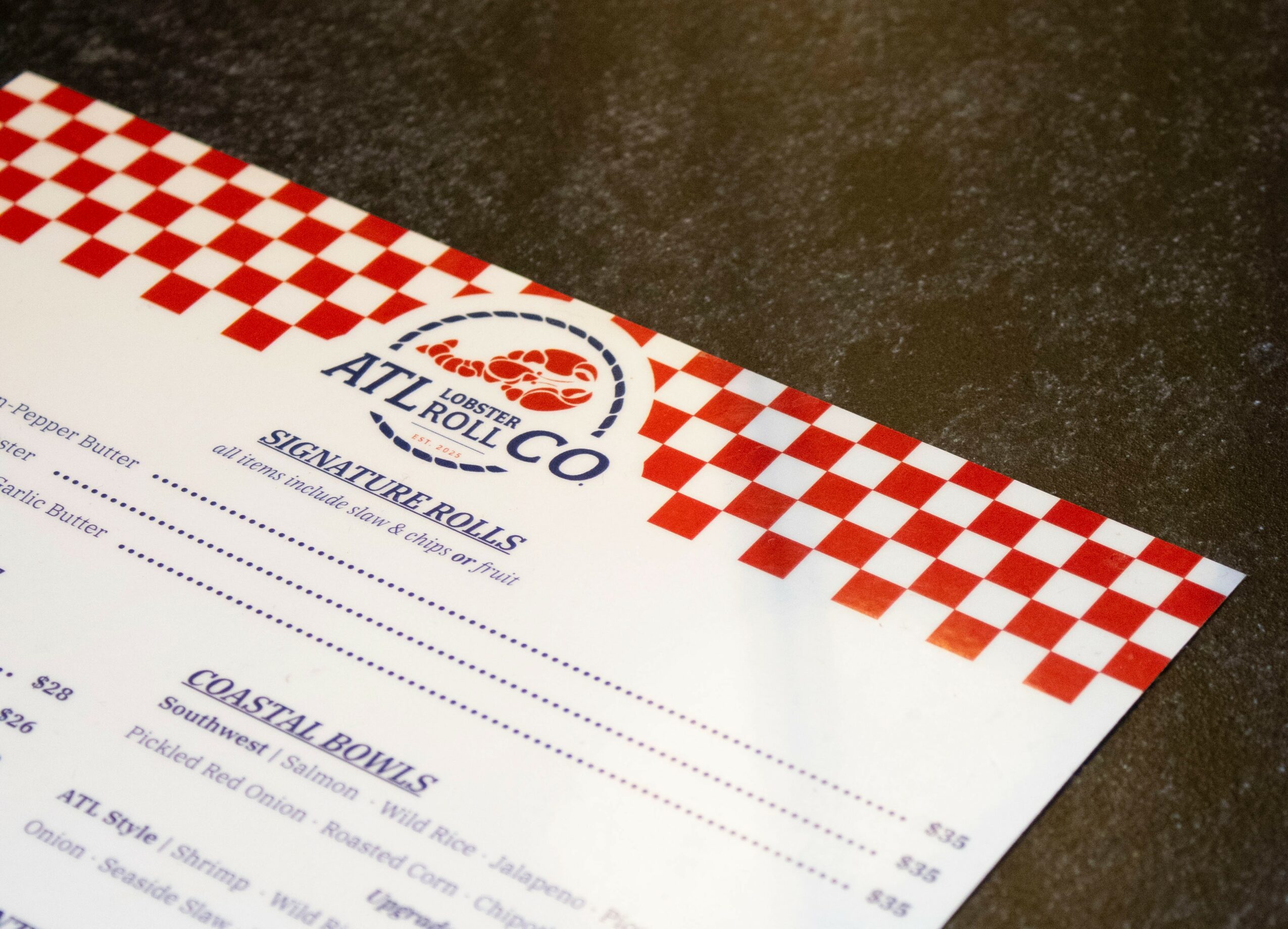 Part of a menu with a red and white checkered border on a dark surface.