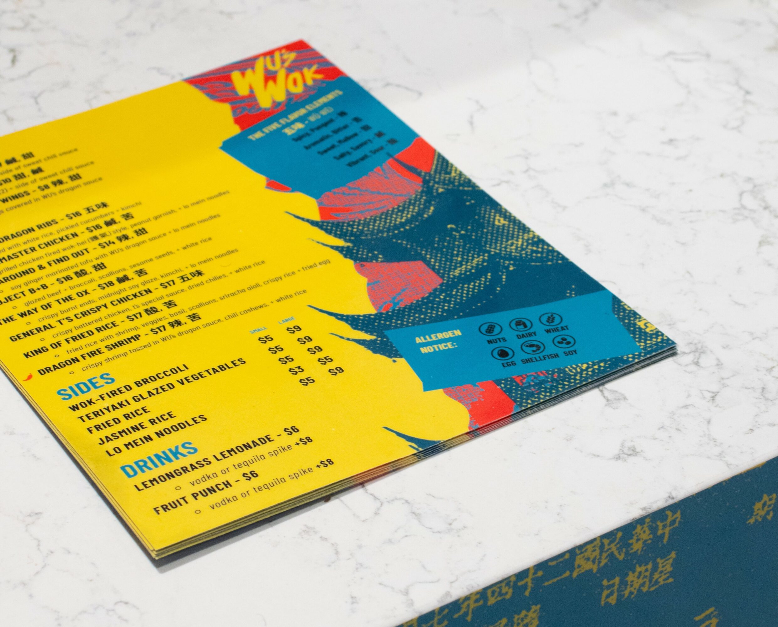 Colorful menu with yellow, blue, and red sections on a white marble surface, partially visible text and graphics.