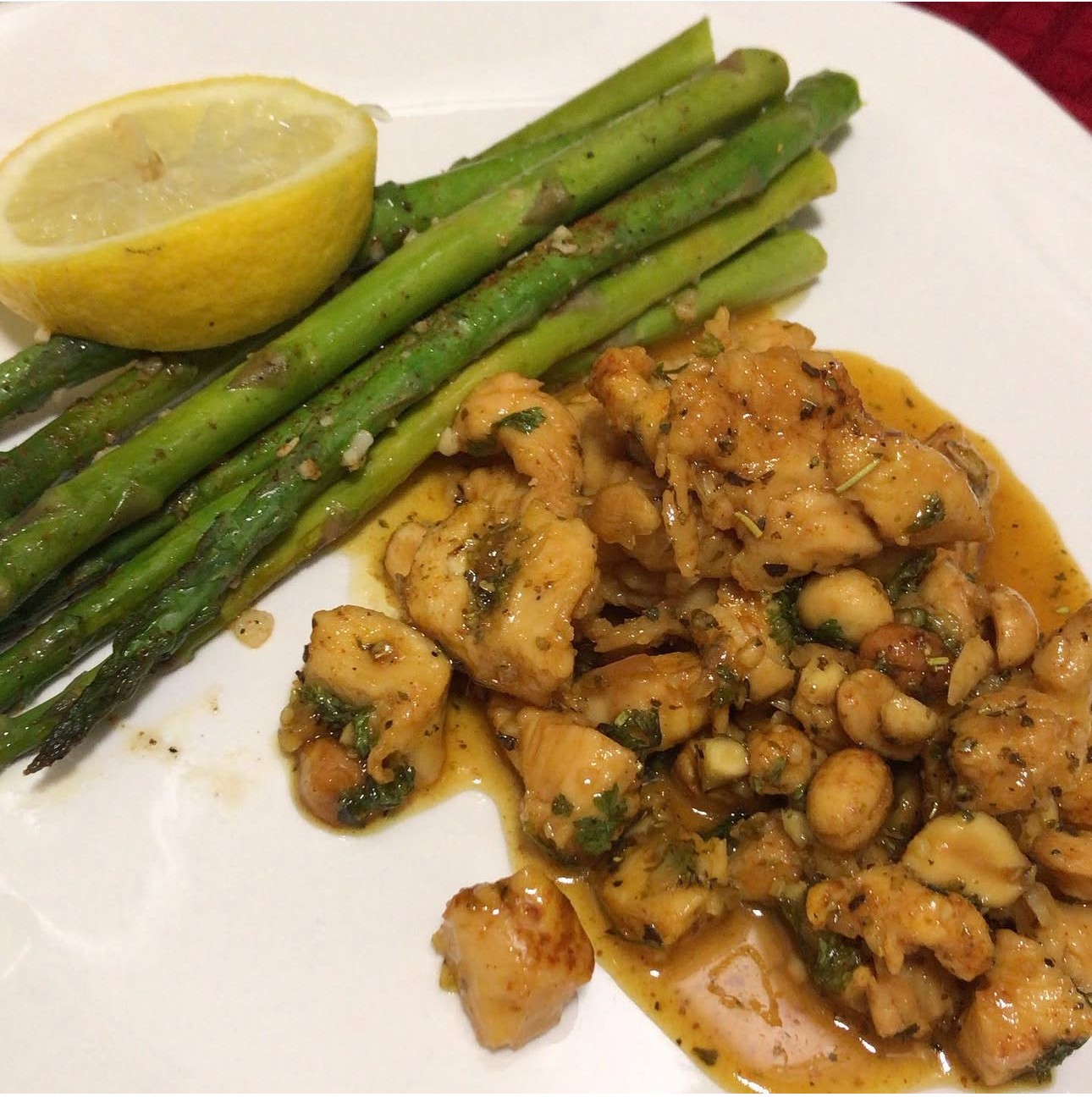 Cooked chickpeas with herbs, green beans, and a lemon wedge on a white plate.