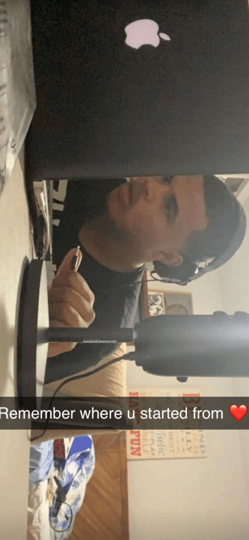 Person with dark hair and beard sitting at a desk, looking to the side, with a computer monitor in front. Text overlay: 'Remember where u started from ❤️'.
